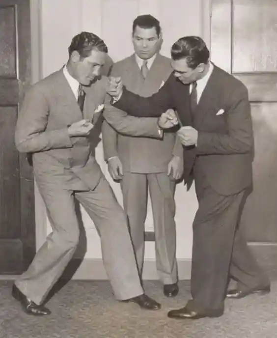 Three men in suits posing with raised fists