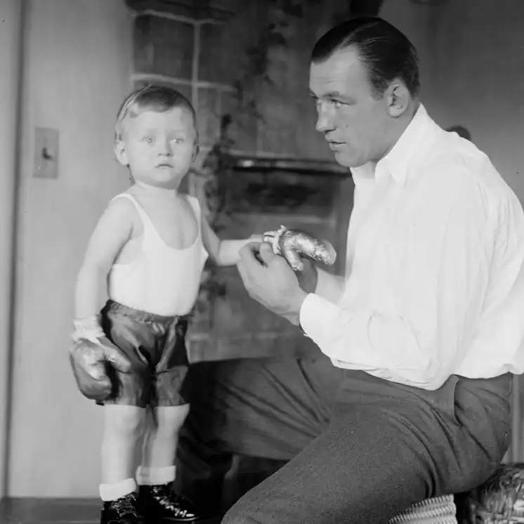Jack Sharkey with a young child wearing boxing gloves