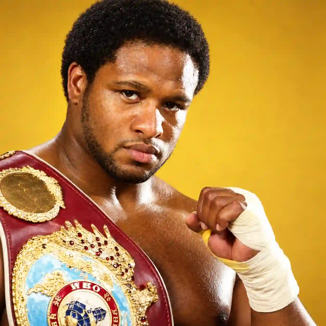 Lamon Brewster with a championship belt and a wrapped fist raised