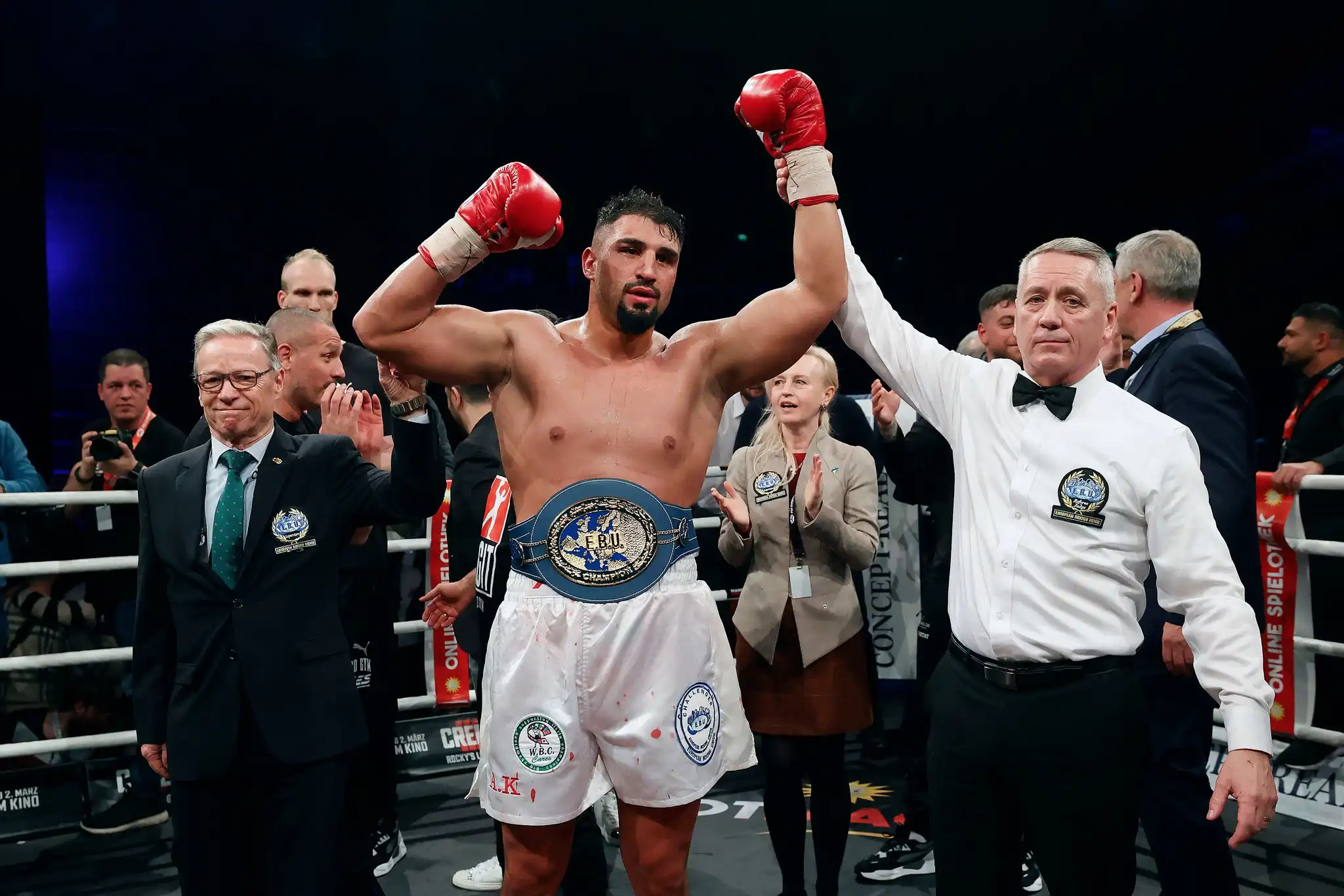 Agit Kabayel raises both red gloves while wearing an EBU championship belt as the referee lifts his arm.