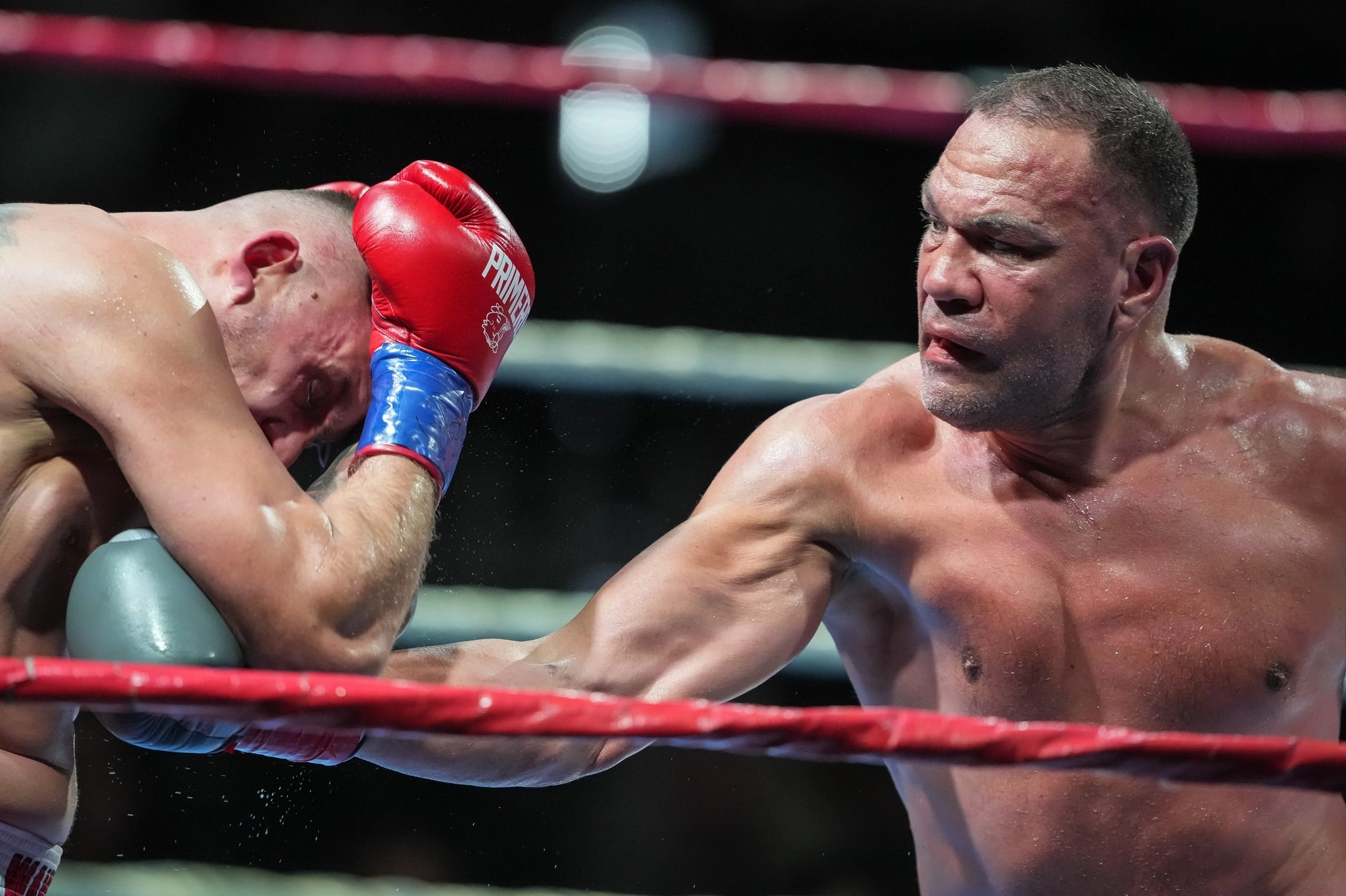 Kubrat Pulev extending a glove toward an opponent covering his head near the ropes.