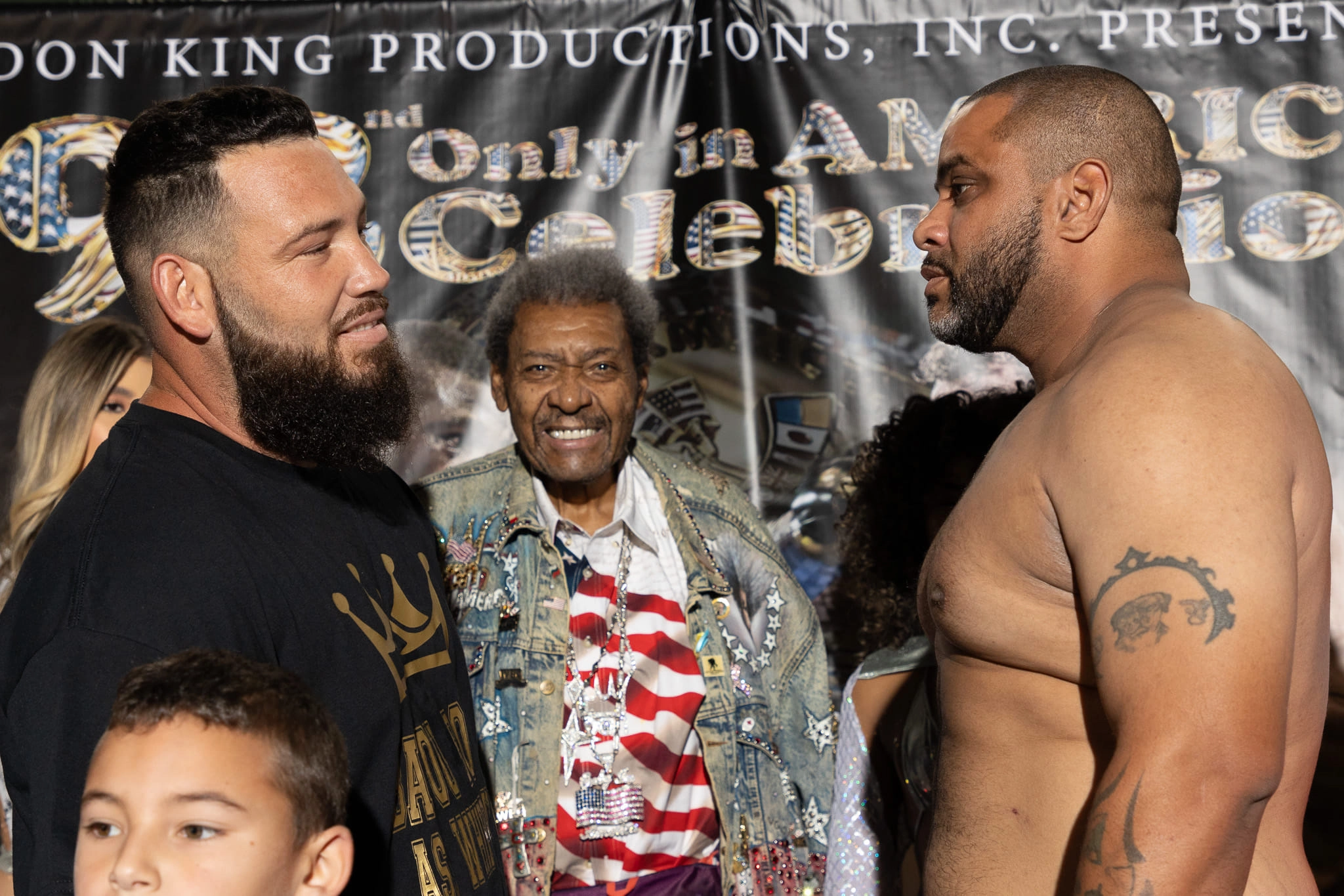 Jonathan Guidry and Jesus Escalara facing each other with Don King between them in front of an event backdrop.