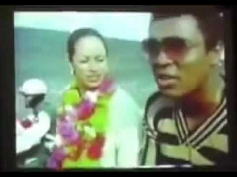 Archival video still showing Muhammad Ali wearing a flower garland beside his wife Veronica during their Bangladesh visit.