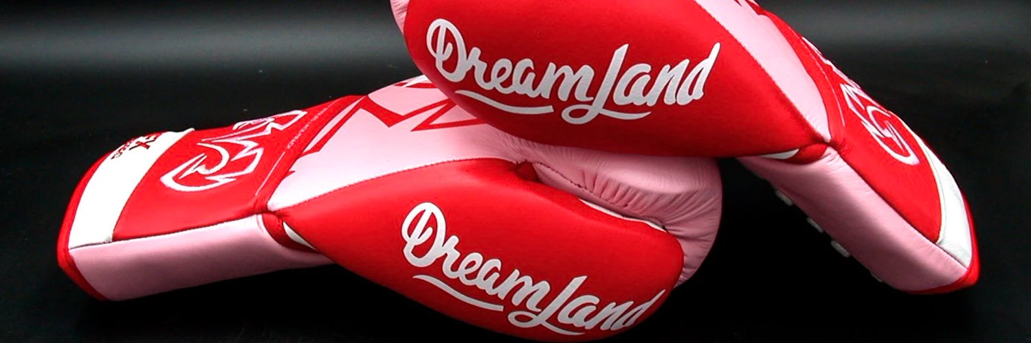 Red-and-white Dreamland boxing gloves against a dark background.