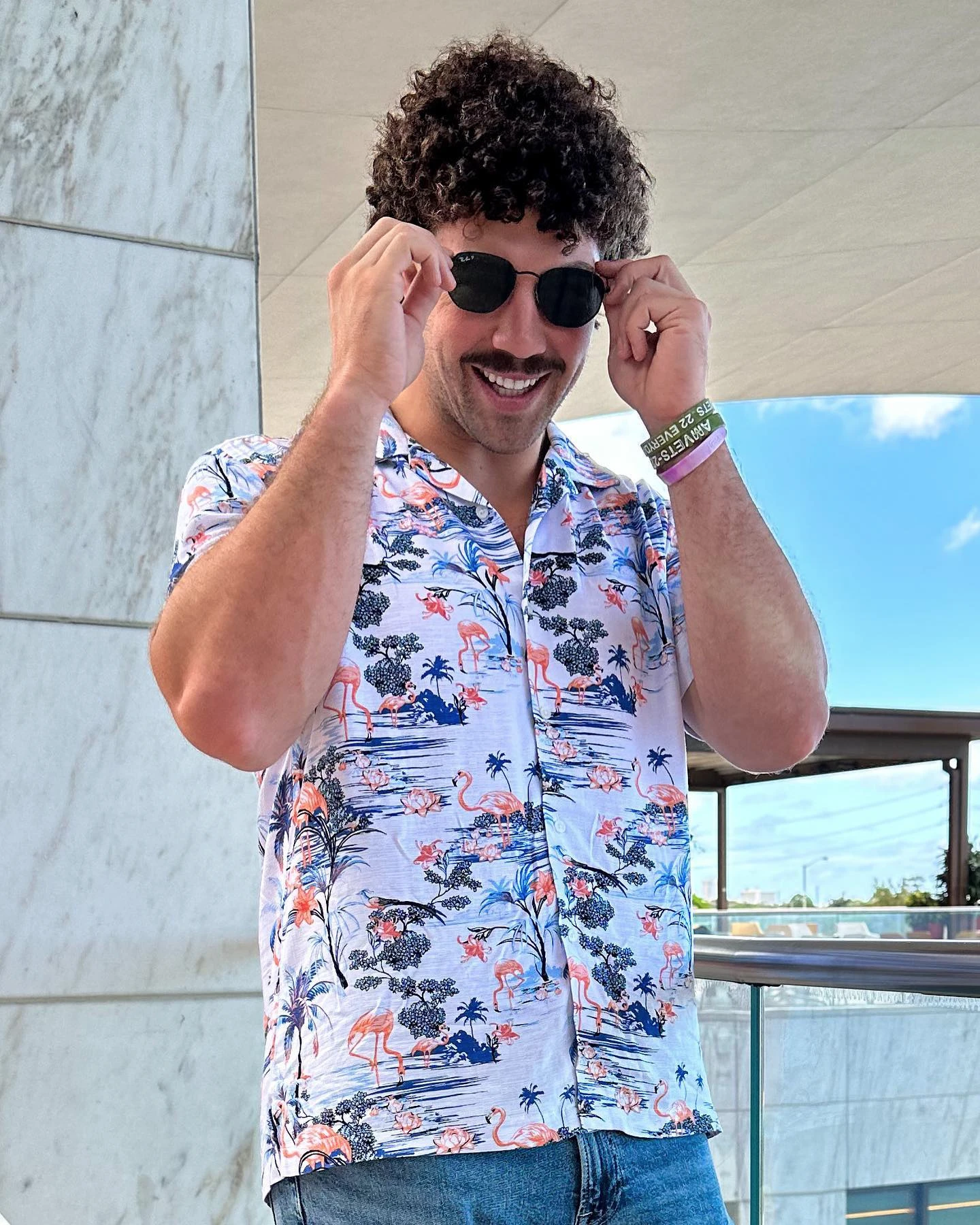 Richard Torrez Jr. adjusts his sunglasses while wearing a patterned shirt.