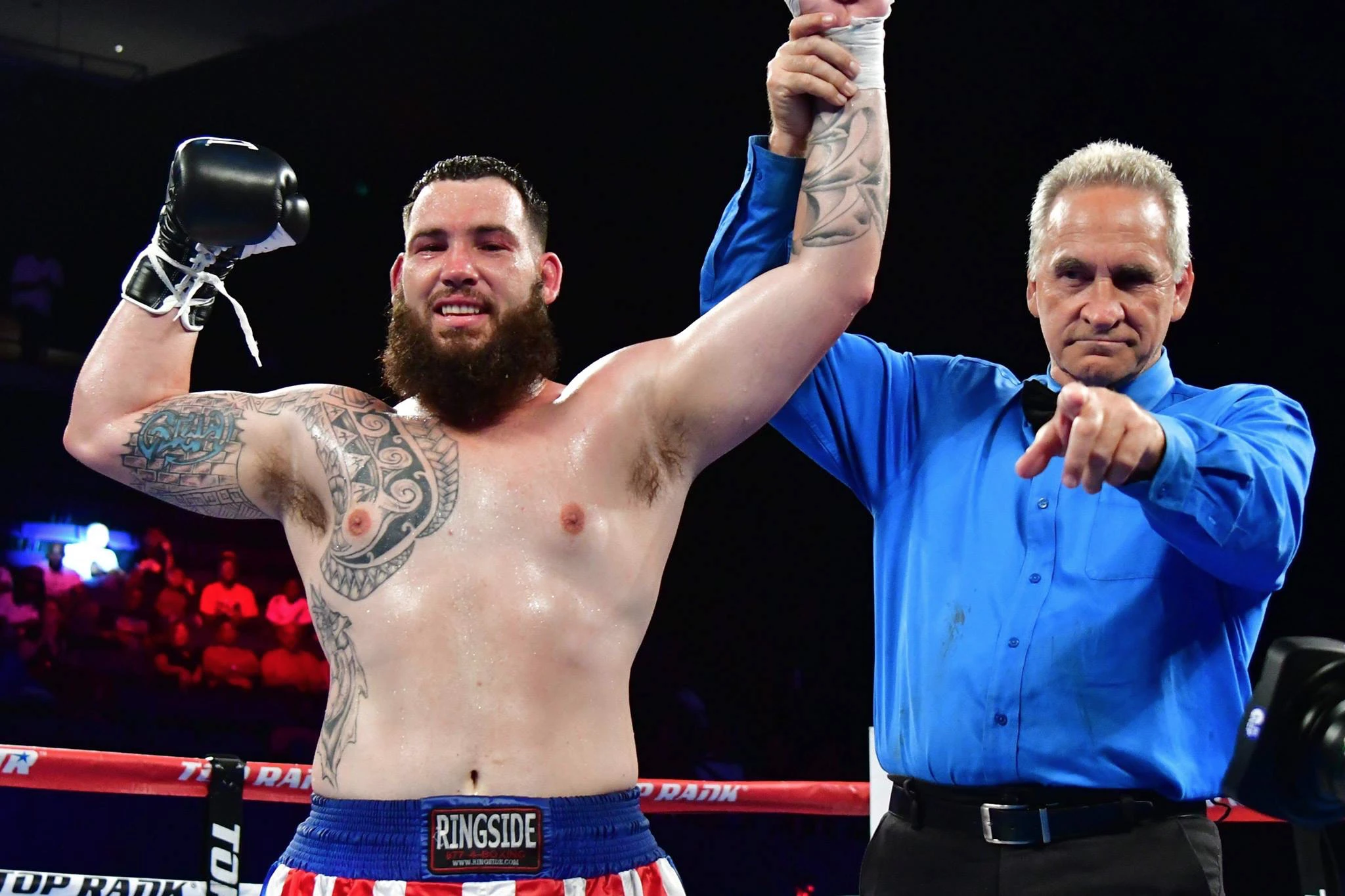 Jonathan Guidry raises his gloves as the referee lifts his arm in victory.