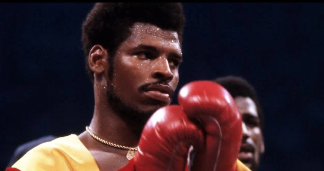 Leon Spinks wearing a yellow robe and red boxing gloves before a bout.