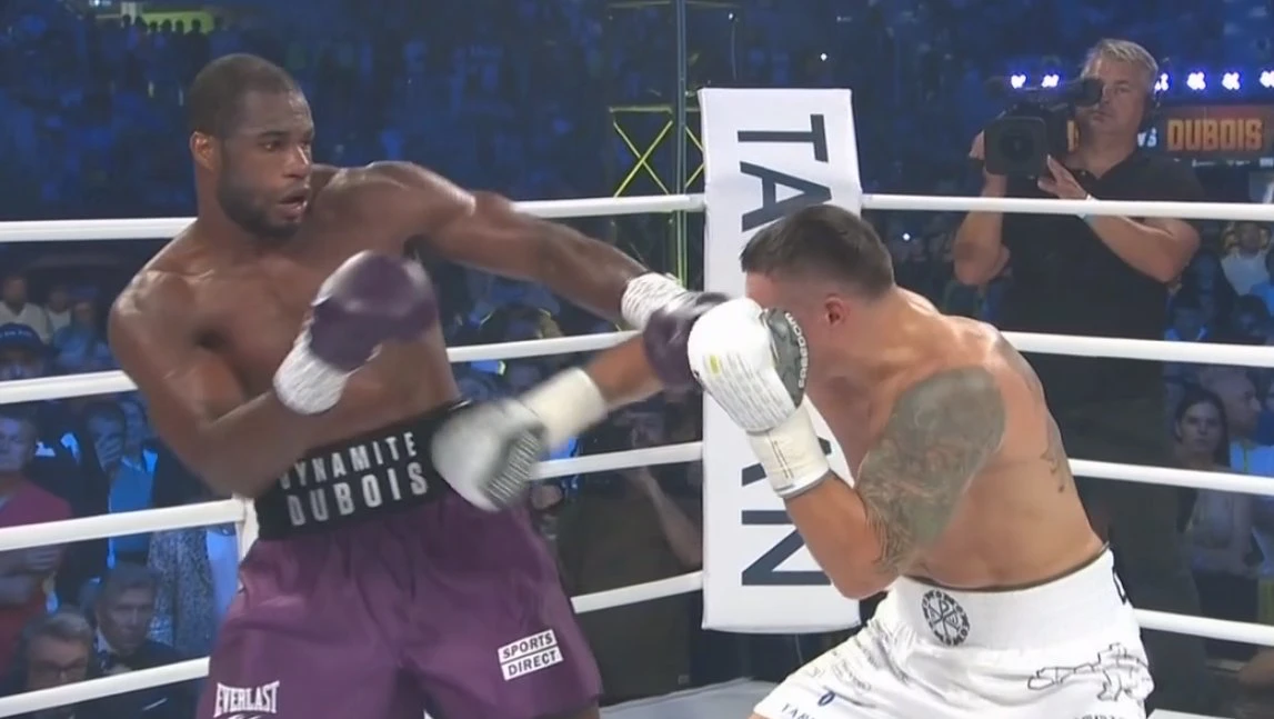 Daniel Dubois extends a punch as Oleksandr Usyk moves behind his guard near the ropes.