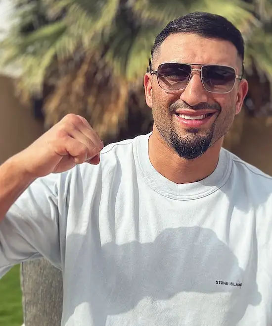 Agit Kabayel wearing sunglasses and raising a fist outdoors