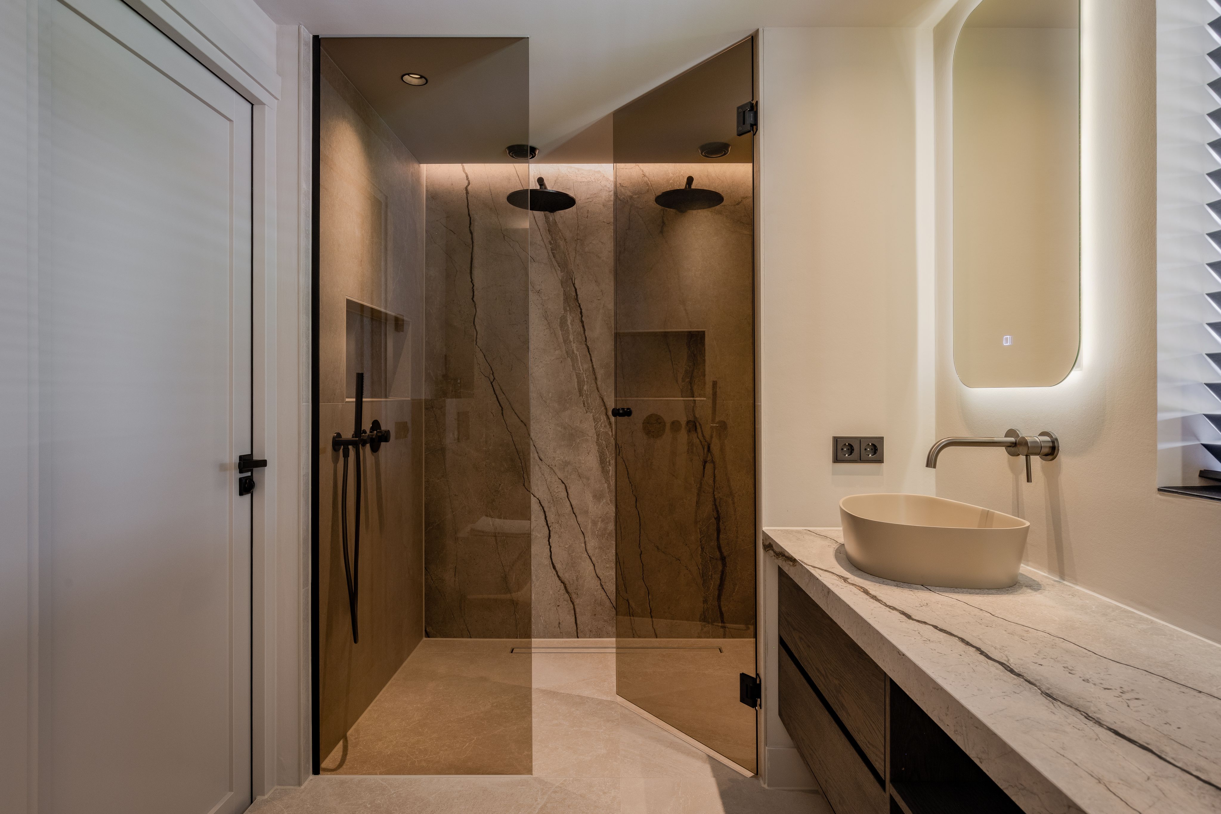 Luxe badkamer met inloopdouche, maatwerk wastafelmeubel en natuursteen