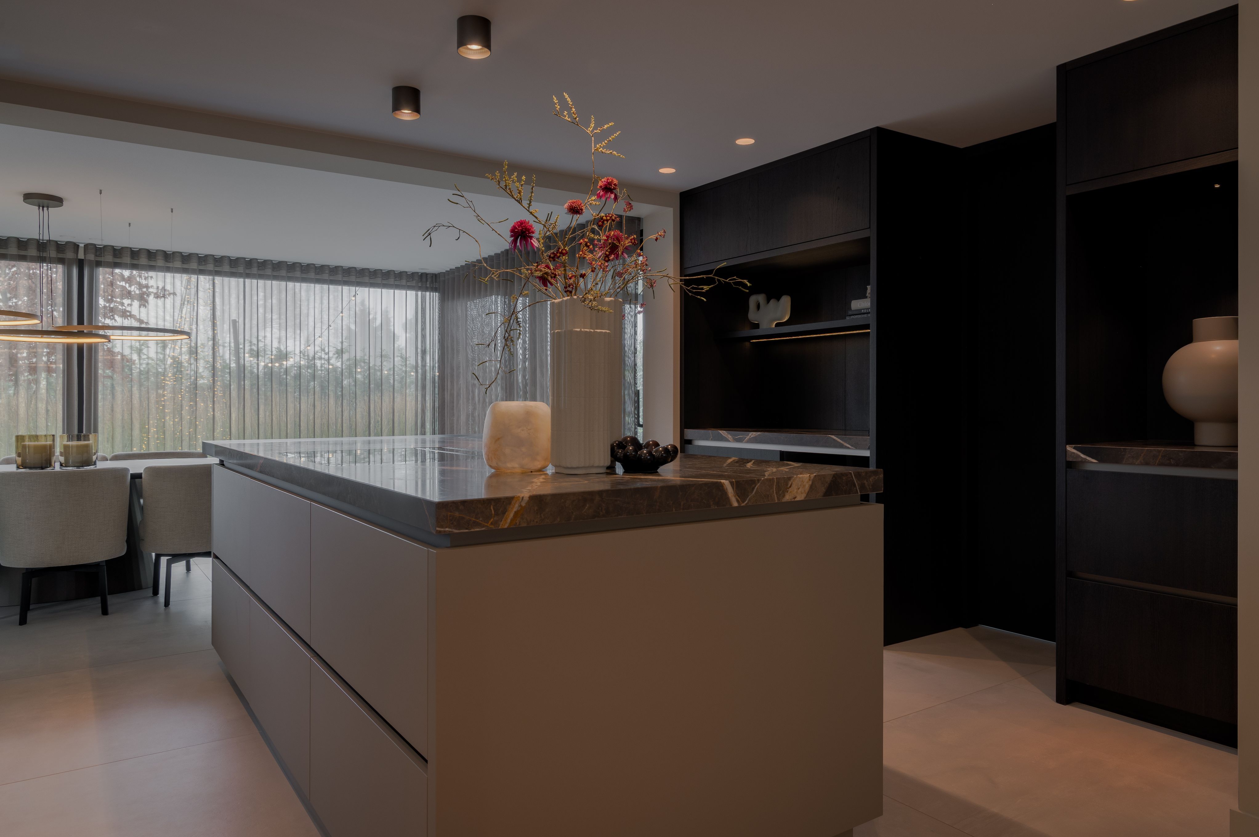 Modern keukenontwerp met groot maatwerk kookeiland en open verbinding naar woonkamer