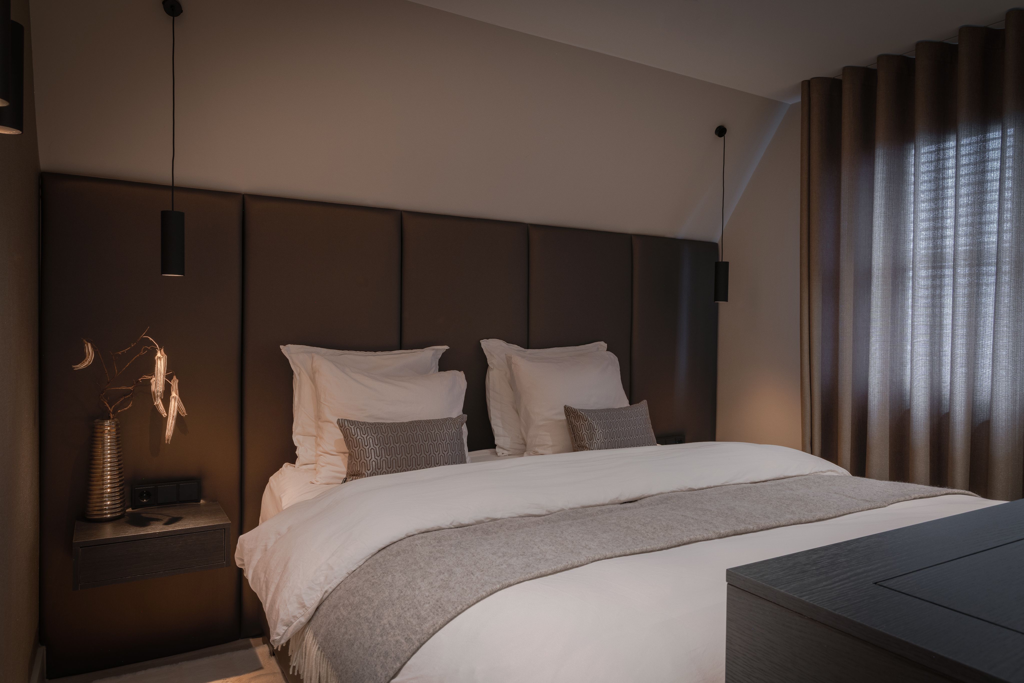 Luxe slaapkamer met maatwerk hoofdbord, zachte neutrale tinten en warme verlichting
