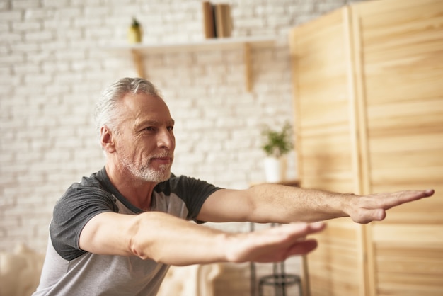 Old man stretching and squatting home exercises. | Premium Photo