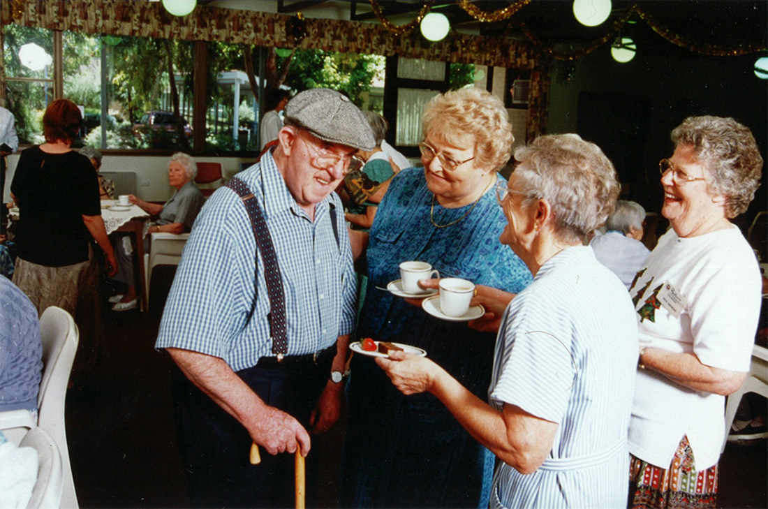group of clients chatting with tea and cake