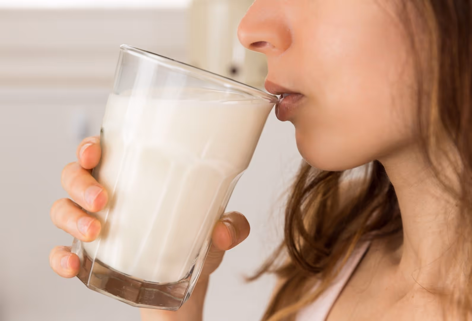 A woman drinks a glass of milk