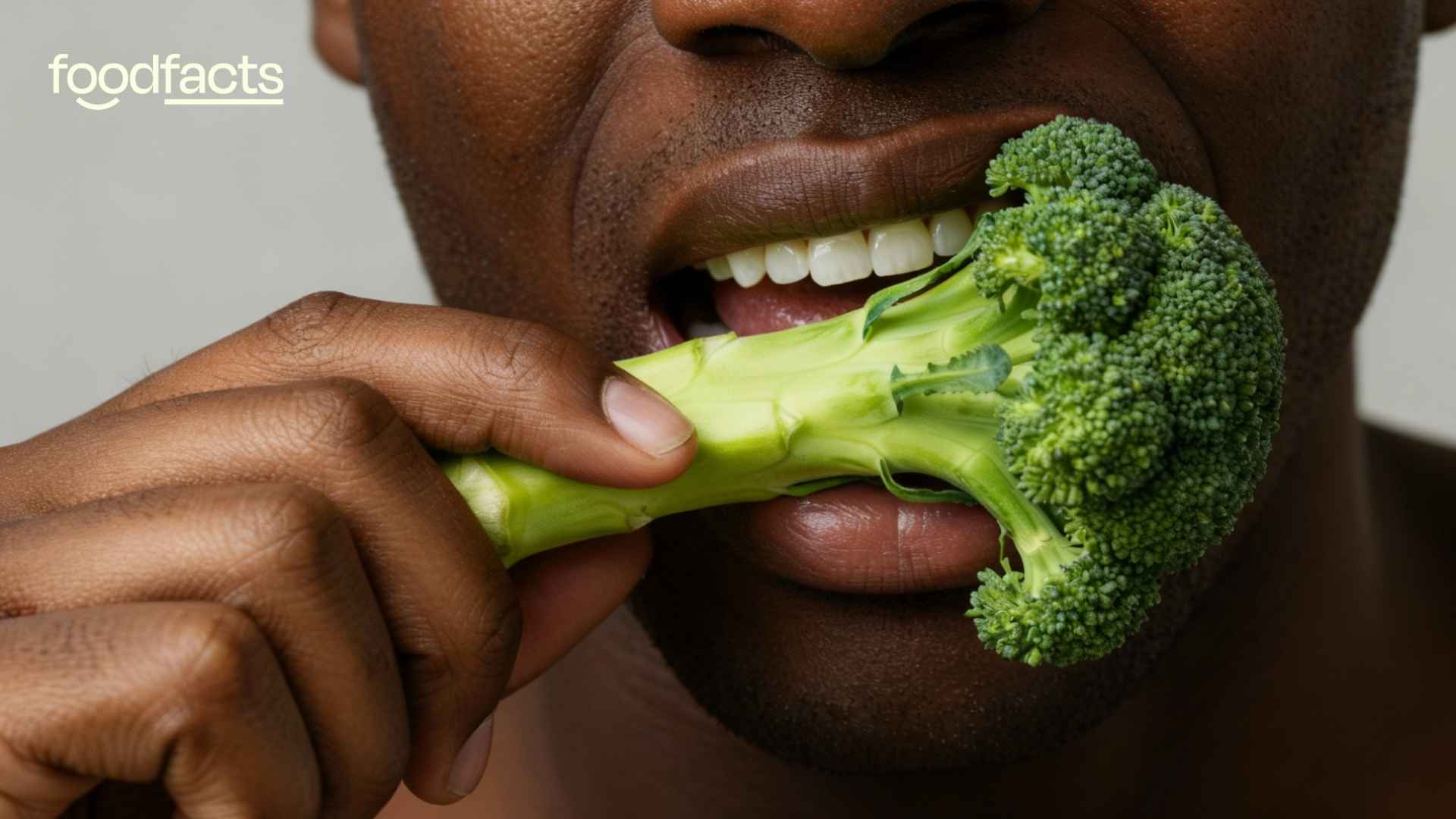 A person holds a broccoli and eats the stalk