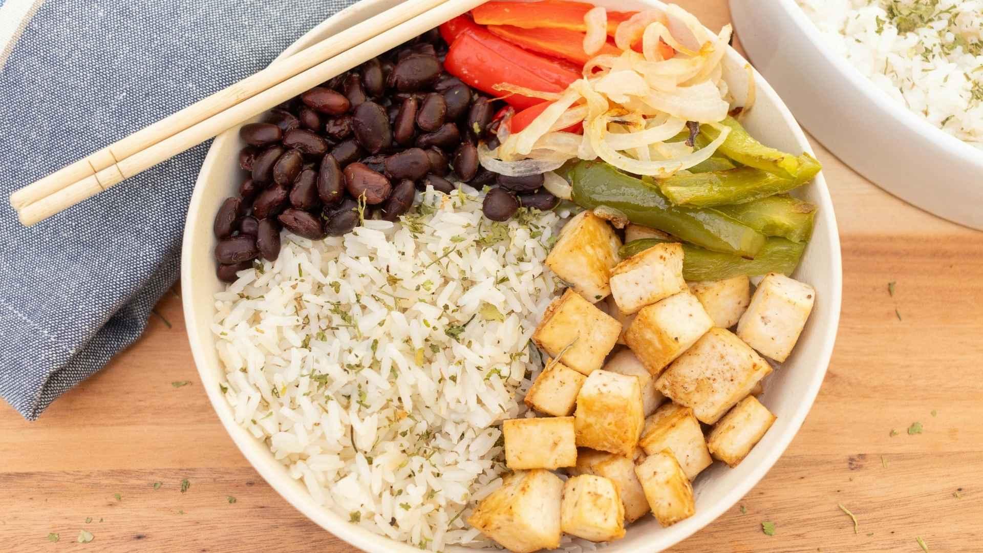 A bowl of rice, beans, tofu, and vegetables