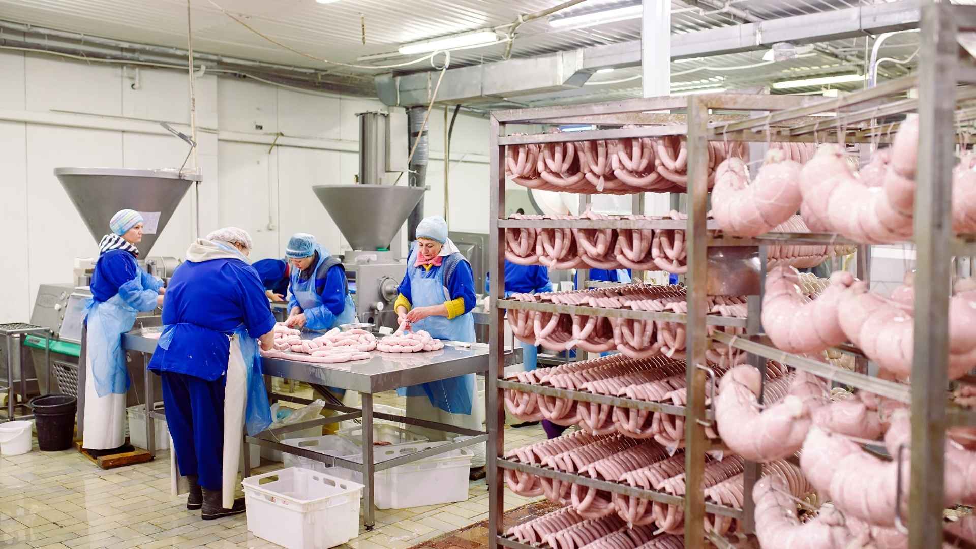Four people working in a meat packing plant