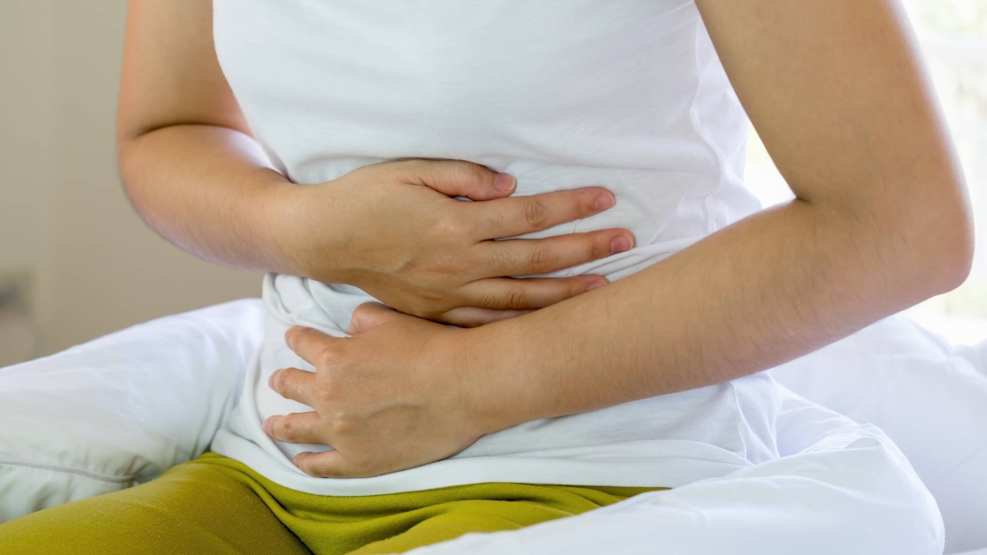 A woman holds her stomach in pain
