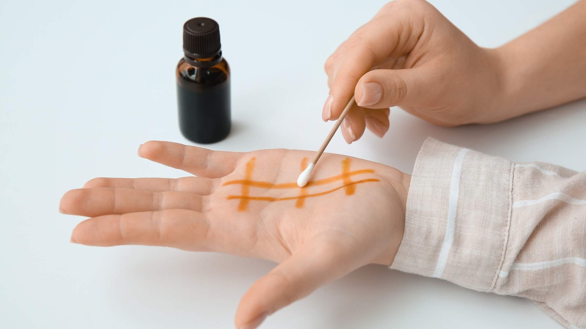 A person wipes their hand with iodine