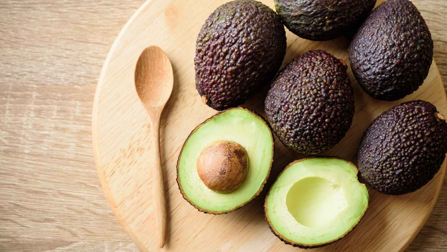 Multiple avocados on a chopping board