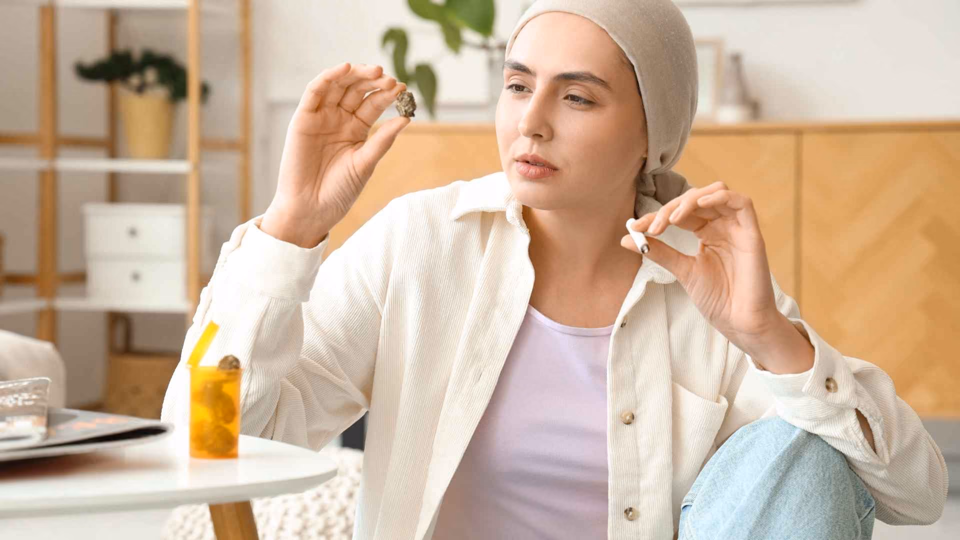 A woman holds a bud of cbd whilst holding a joint