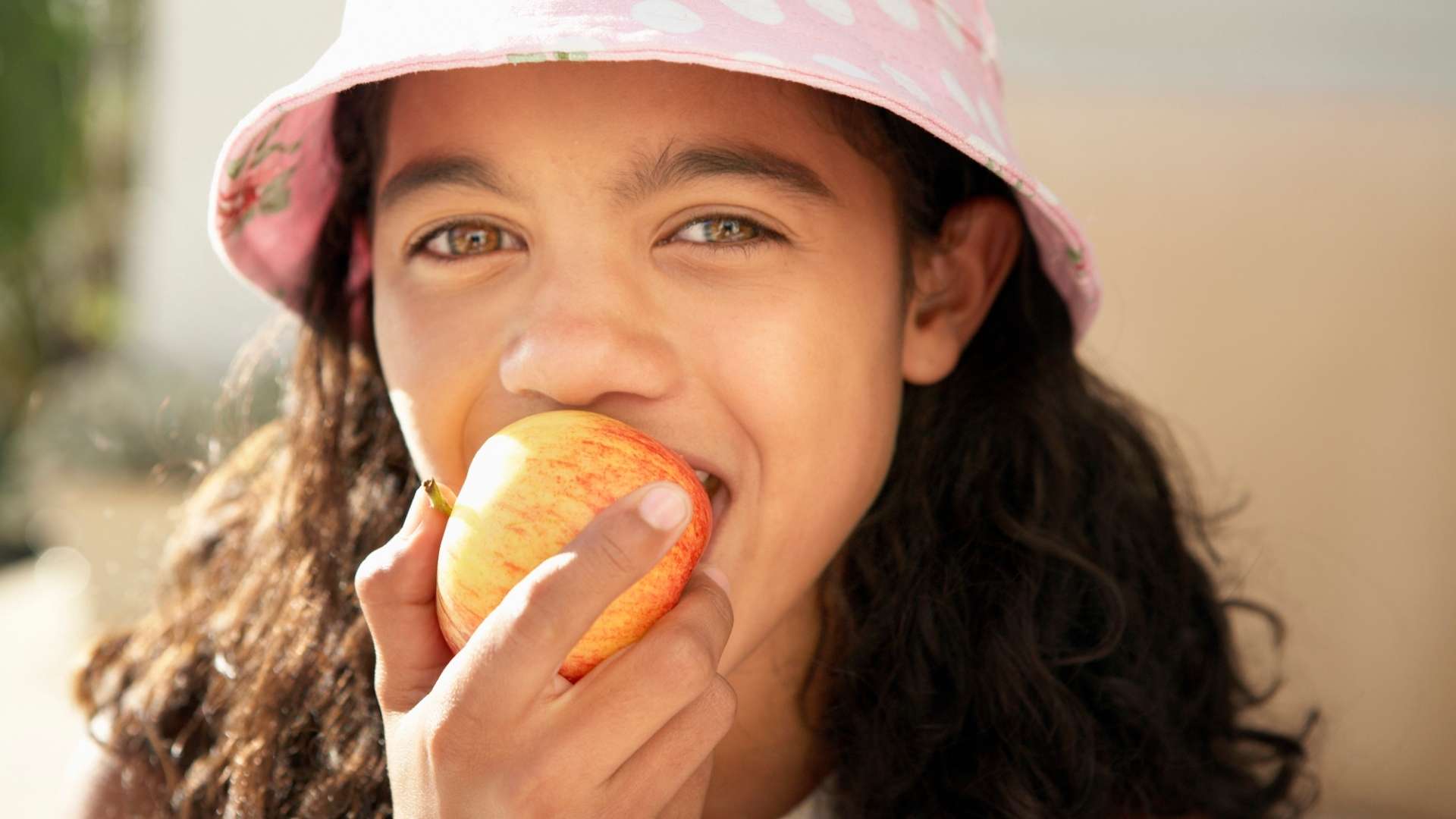 A girl eats an apple