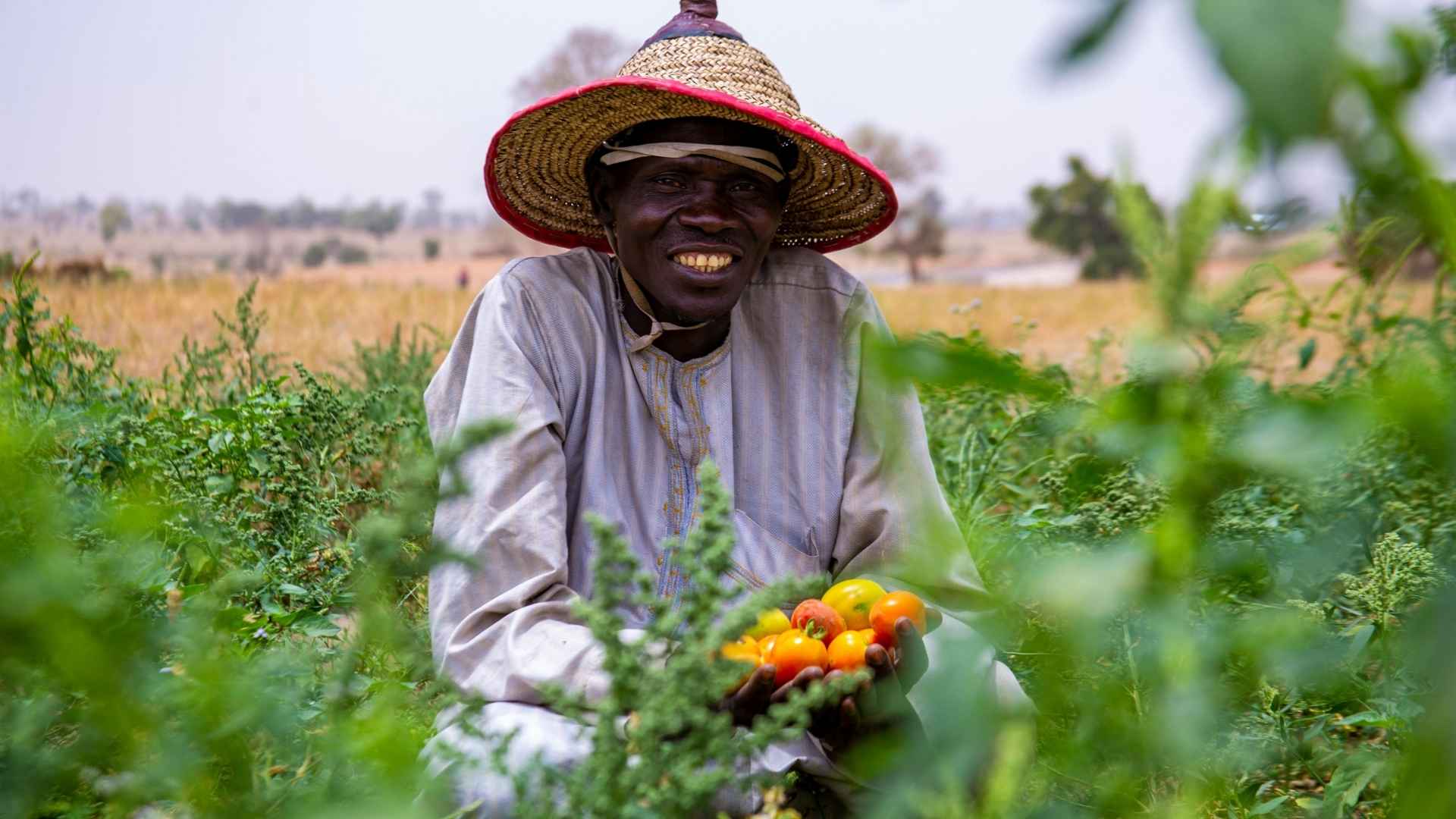 A farmer smiles whilst looking at the camera