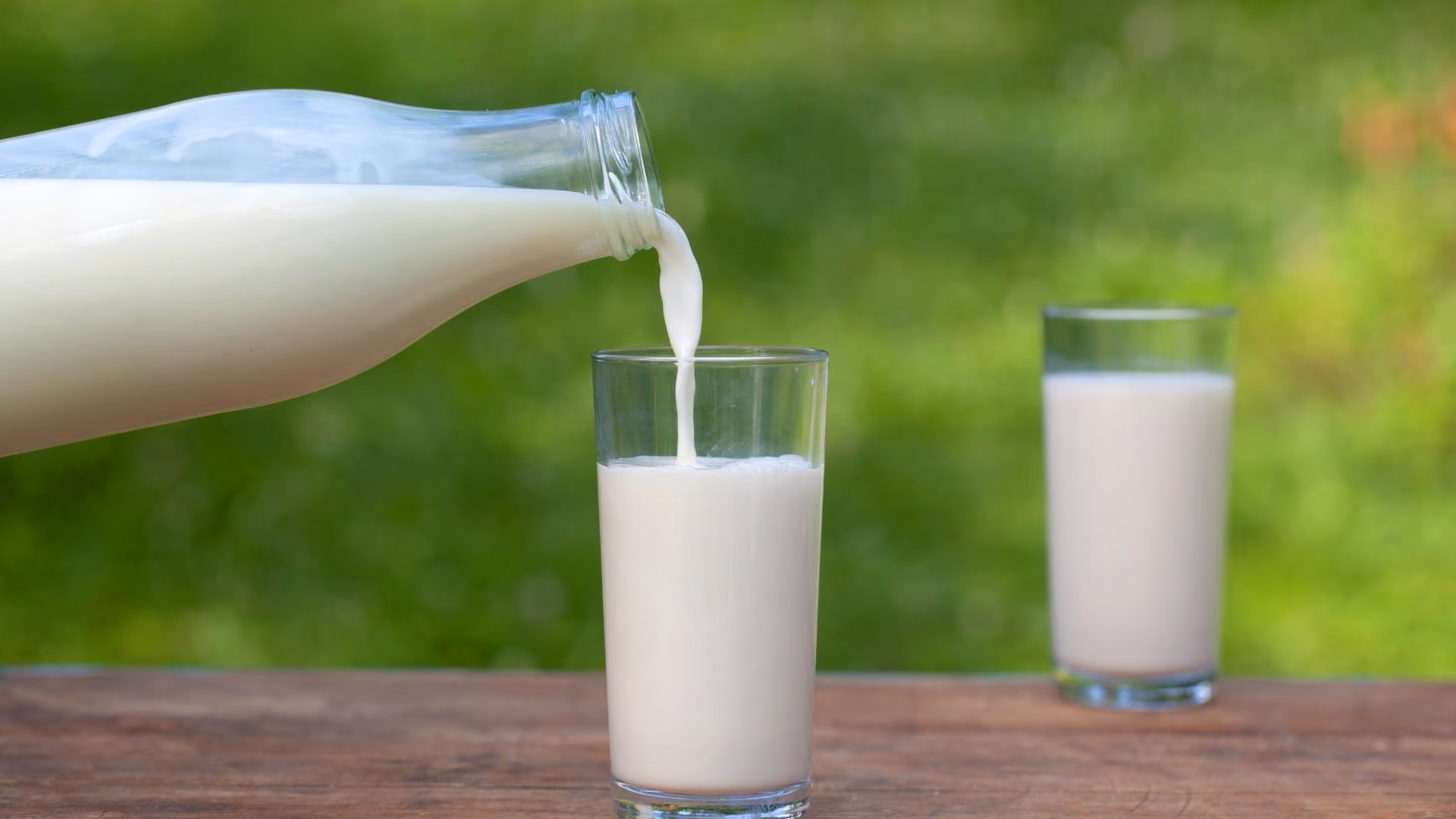 A bottle of milk is poured into a glass