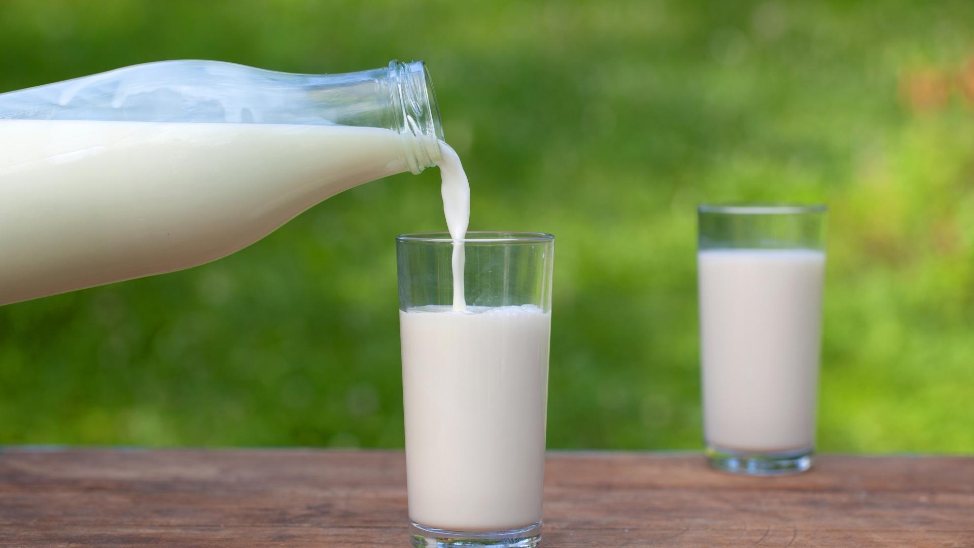 A bottle of milk is poured into a glass