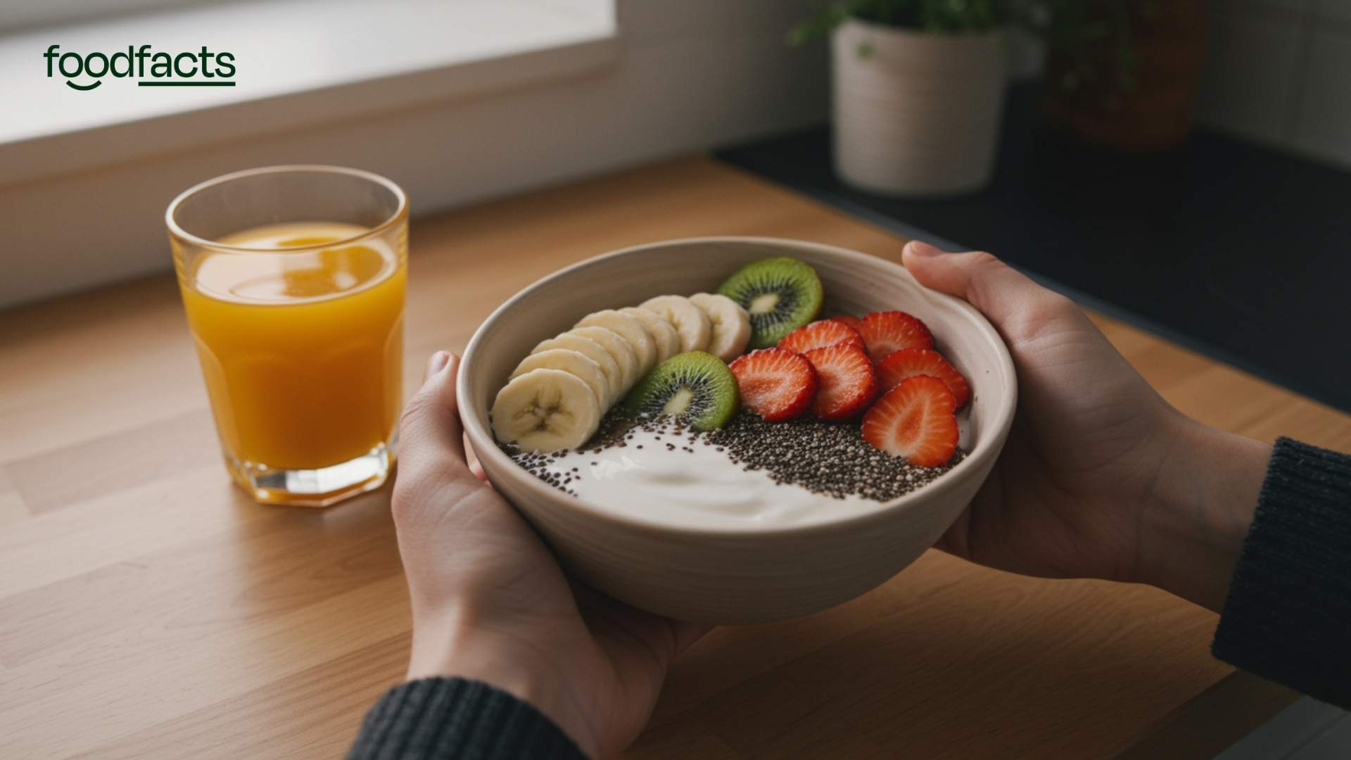 A person holds a bowl of chia seeds, yoghurt, and fruit. This symbolises the fact that many people enjoy this as a breakfast option.