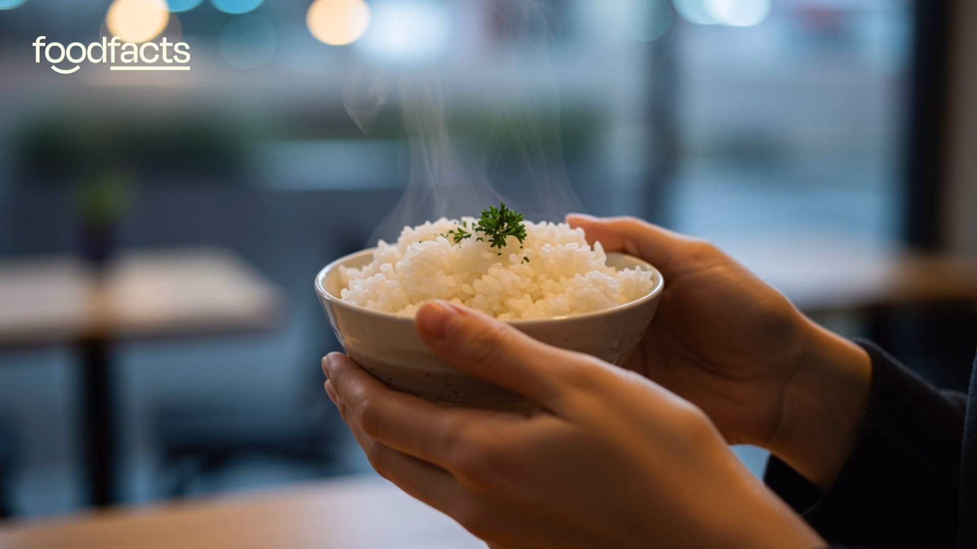 A person holds some white rice and washes it