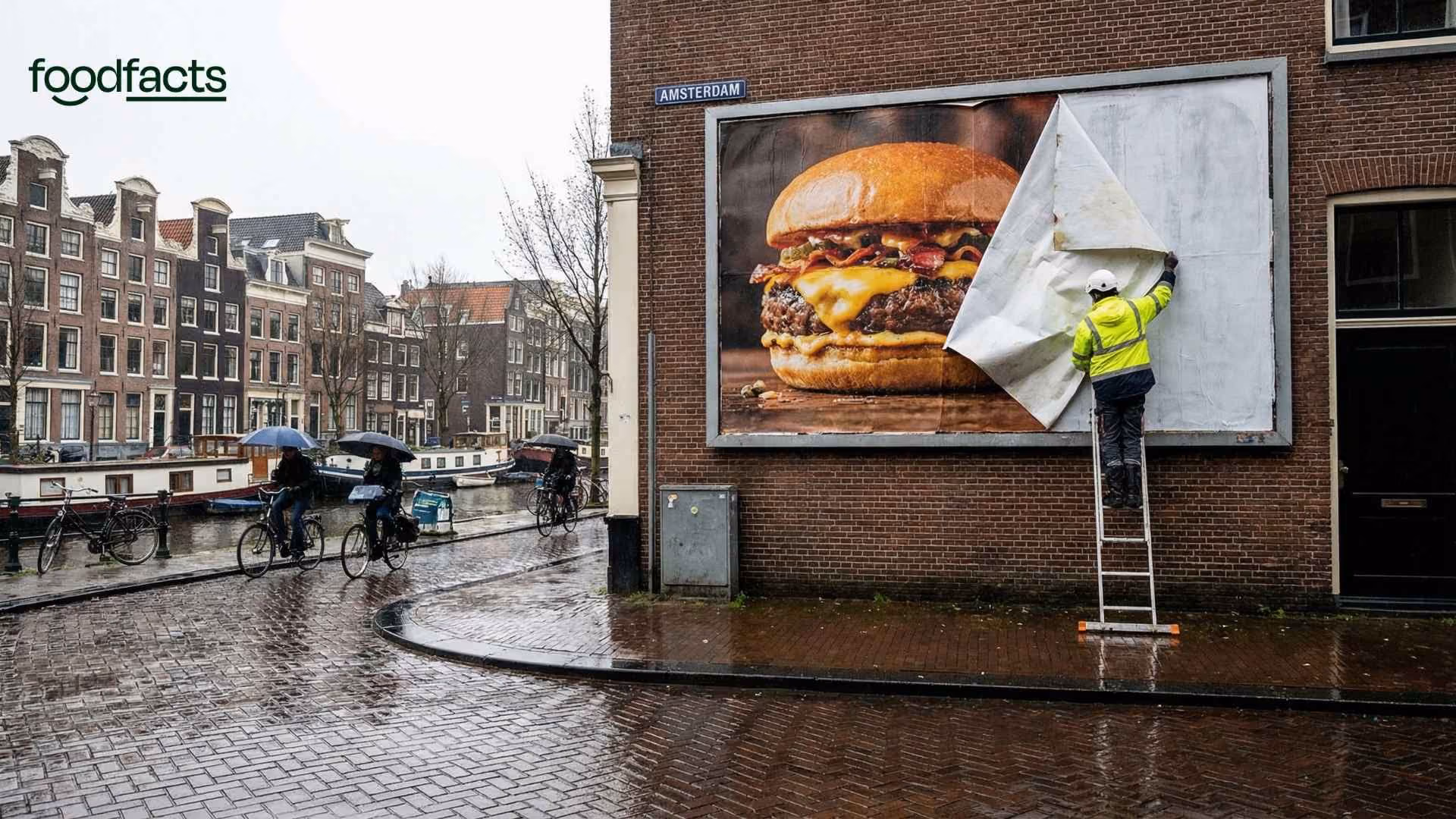 A person removes a meat advert from a street in Amsterdam