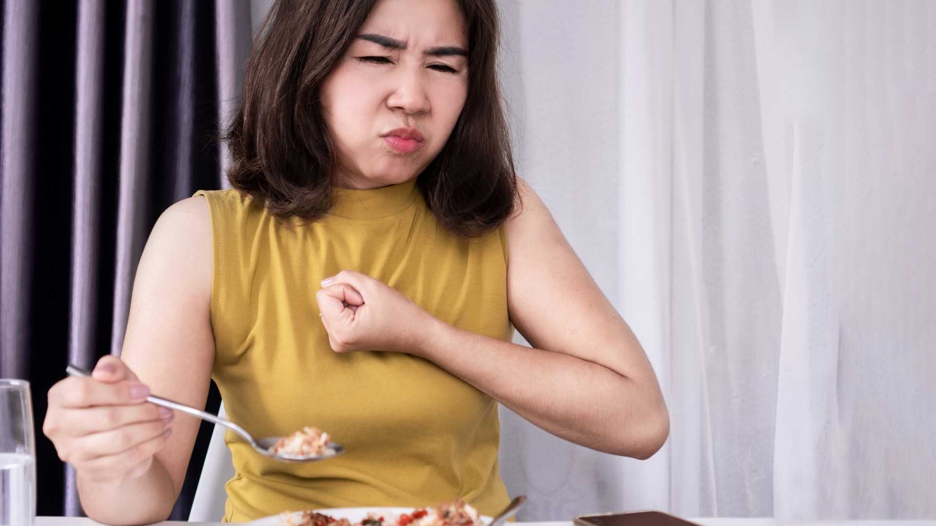 A woman struggles to swallow her food