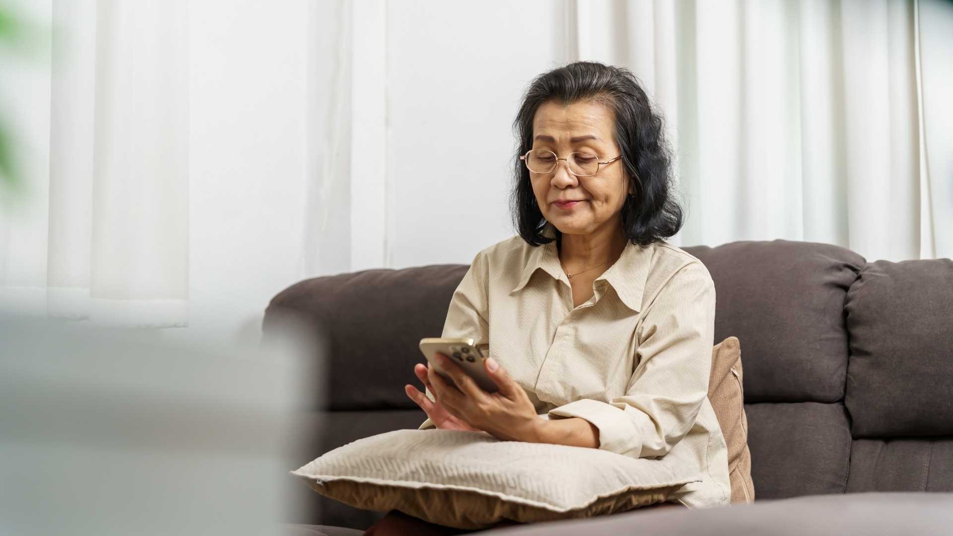 A middle-aged woman looks at her phone