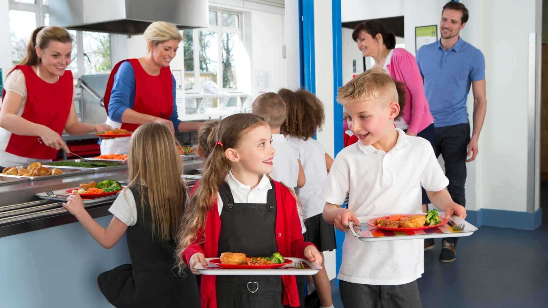 Young school children eat food in a school cafeteria