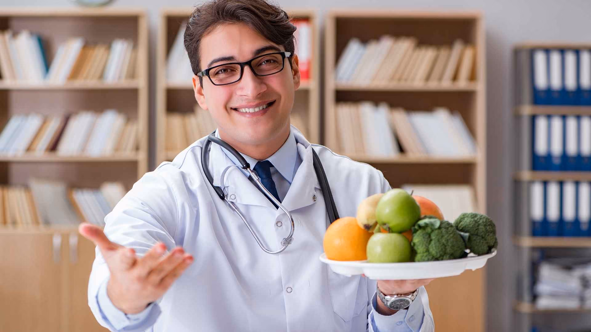 A doctor holds a bowl of fruit and vegetables