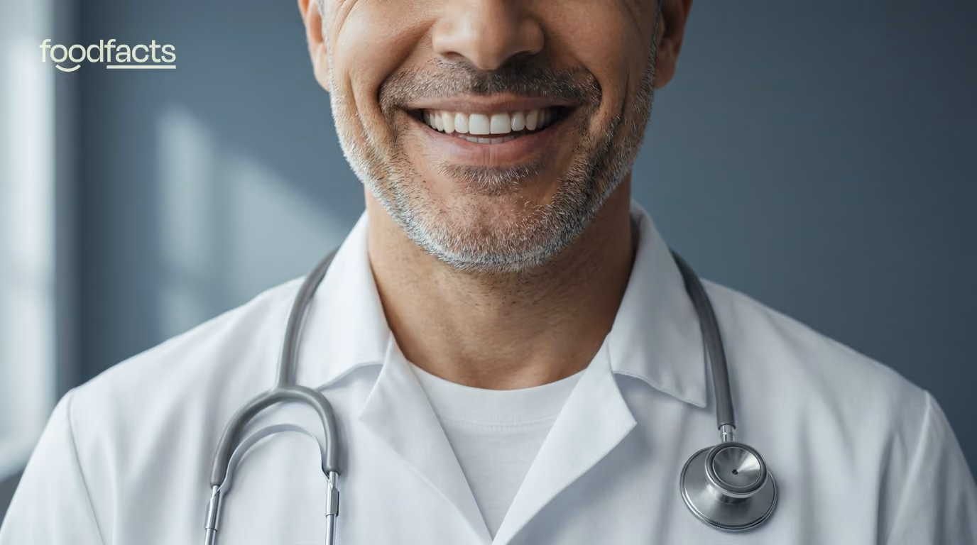 Conceptual editorial portrait of a doctor in a white coat, with the top of the face cropped above the smile — symbolising borrowed clinical authority. FoodFacts.org feature image.