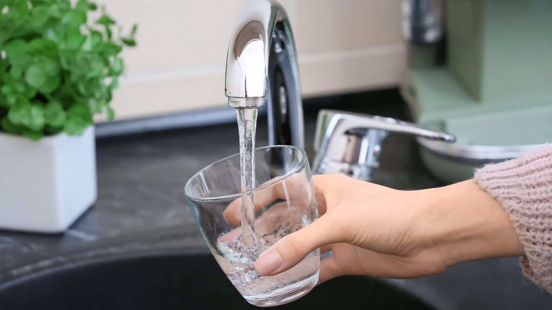 A person fills a glass with tap water