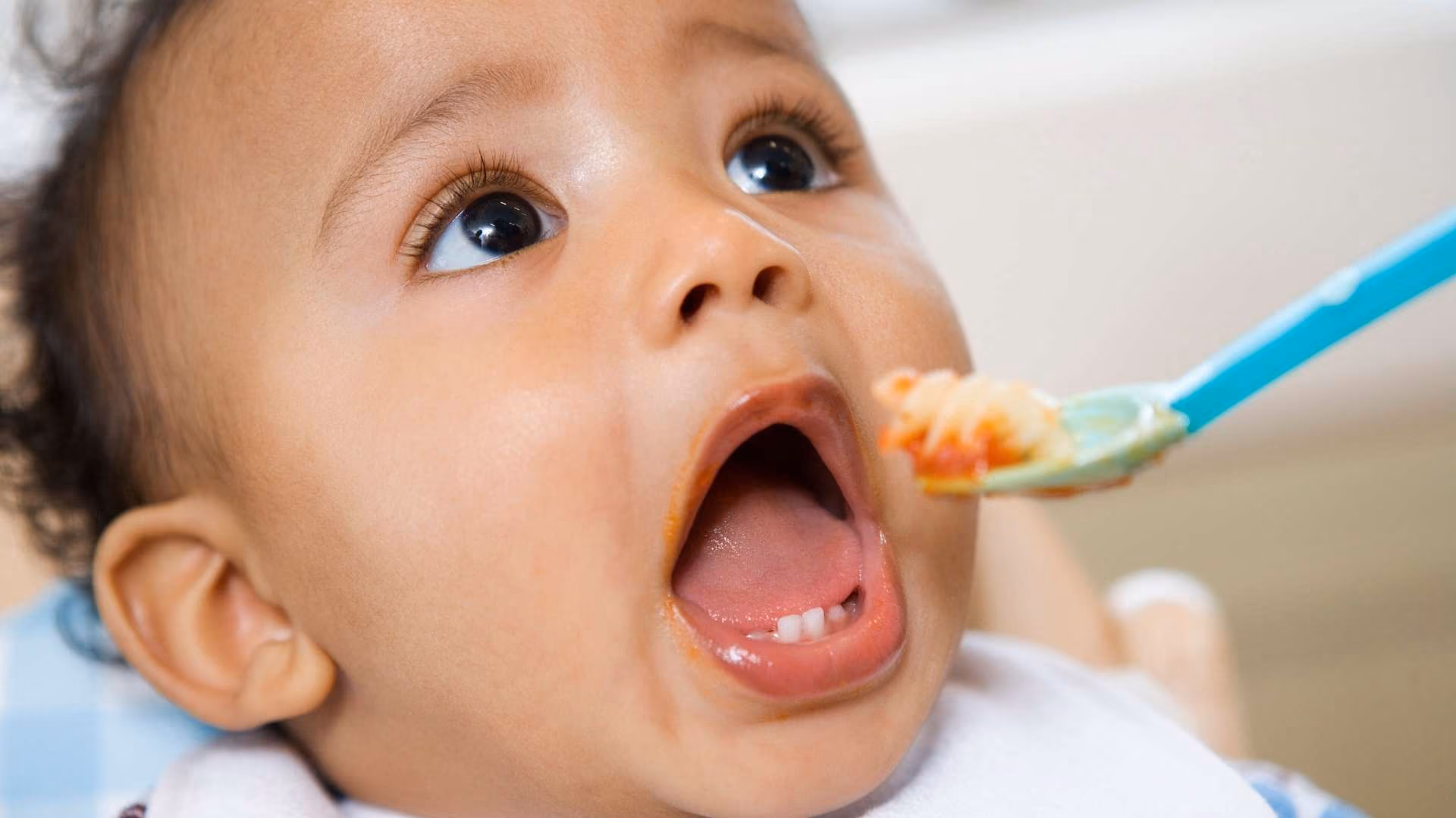A baby eats food