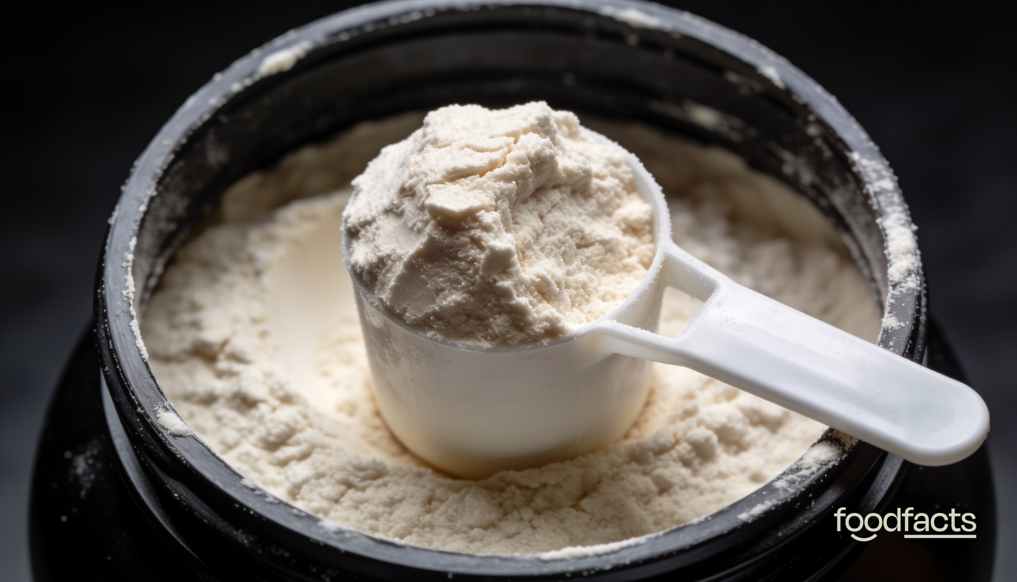 A scoop of creamy whey protein powder resting on an open tub of protein powder