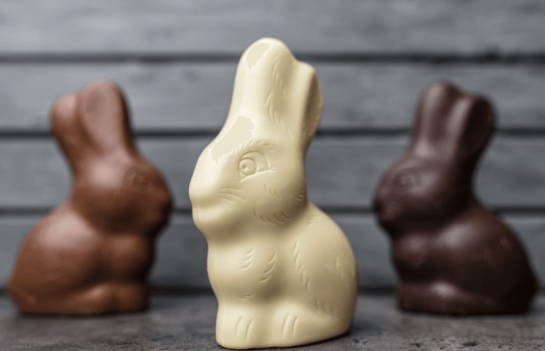 Three chocolate bunnies. One is made from dark chocolate, one from milk chocolate, and the other from white chocolate.
