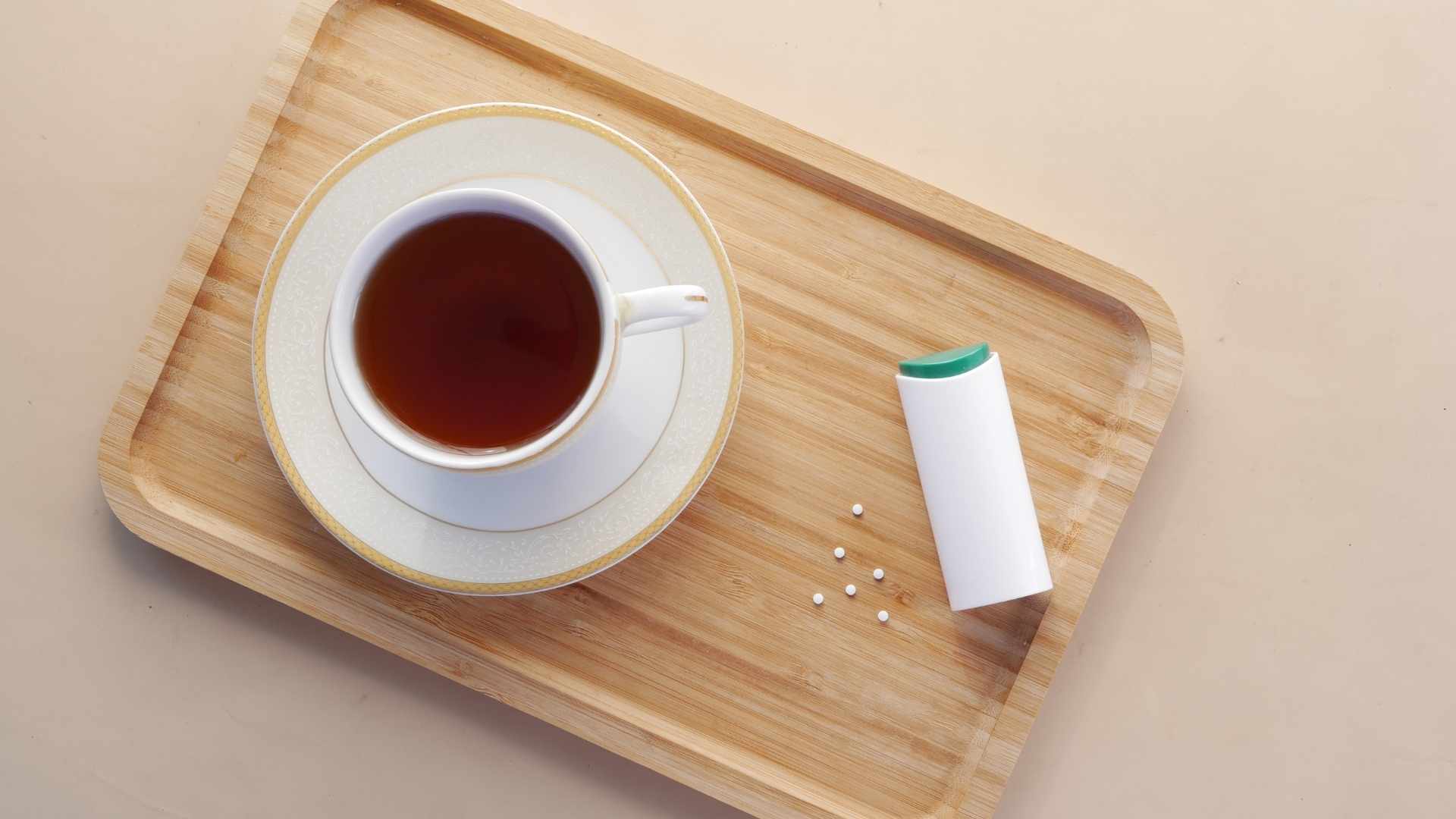 A cup of tea next to sweeteners