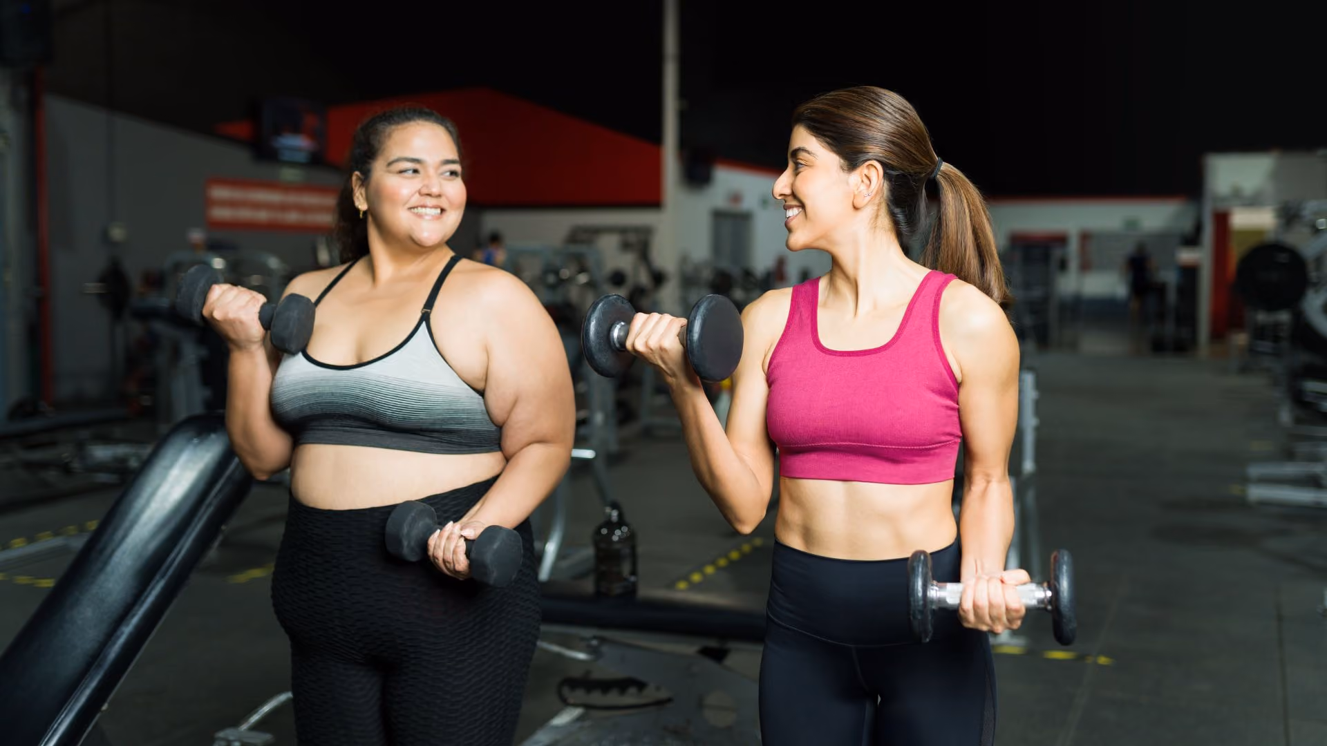 Two people exercise in a gym