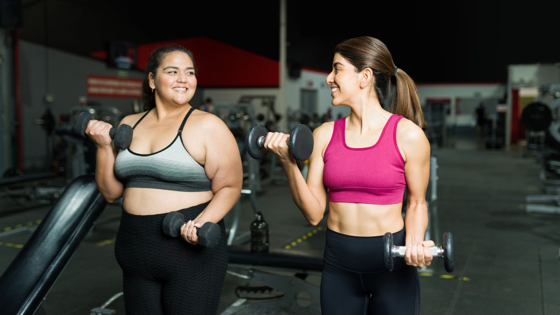 Two people exercise in a gym