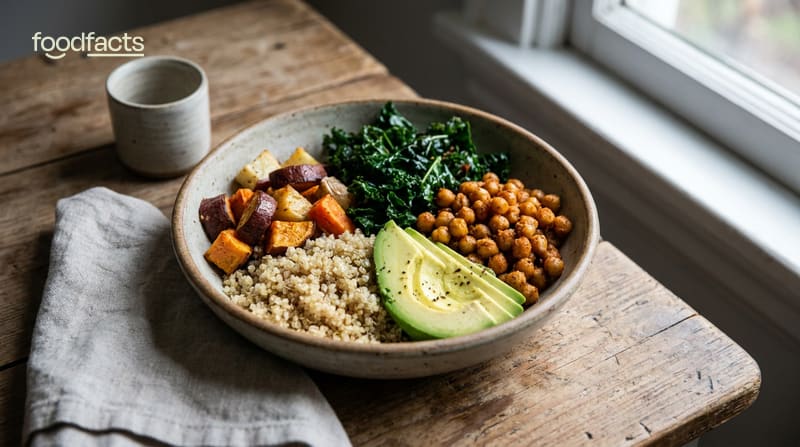 A balanced healthy meal bowl with grains, roasted vegetables, leafy greens, chickpeas and avocado