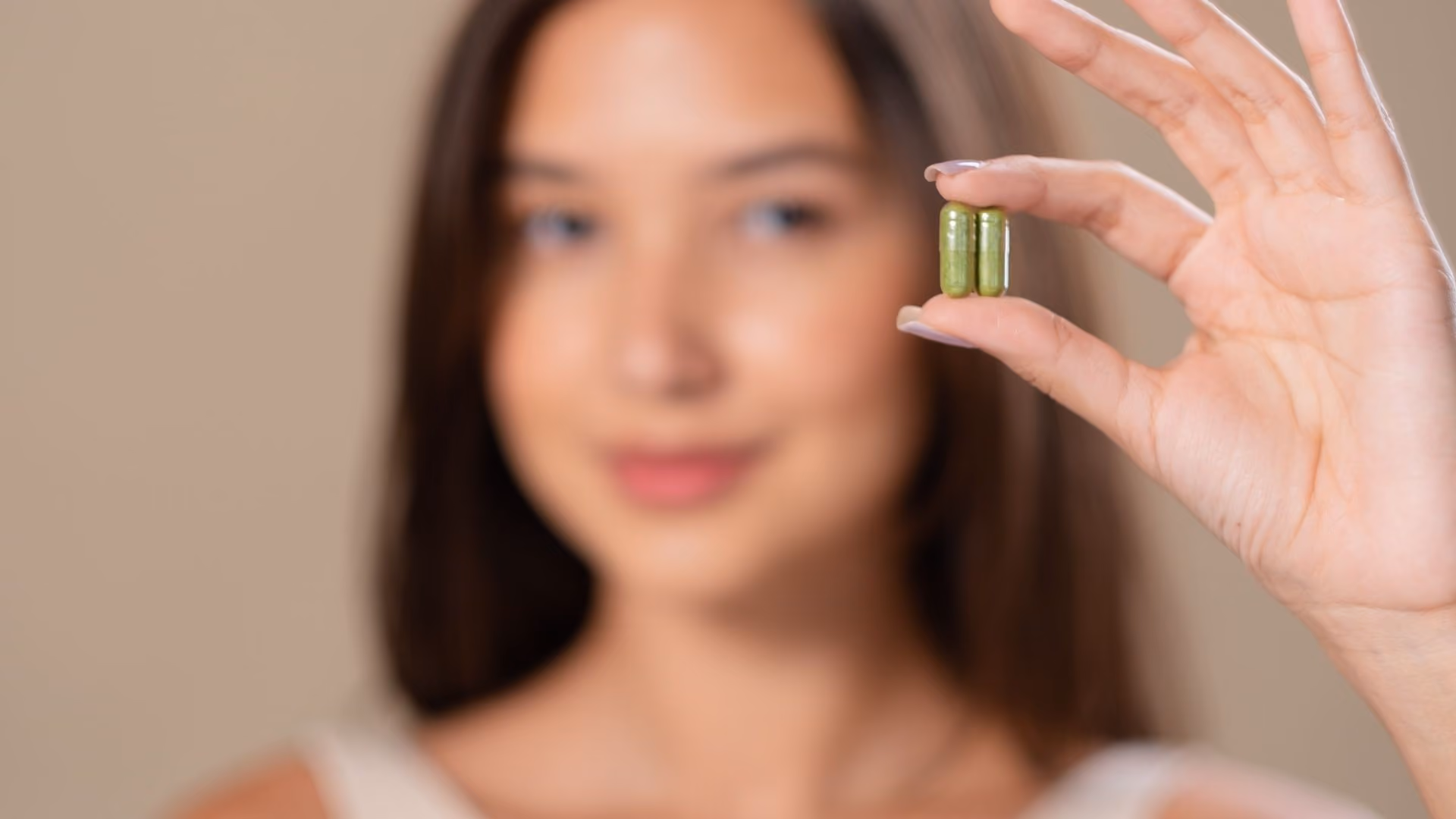 A person holds supplements in their hand