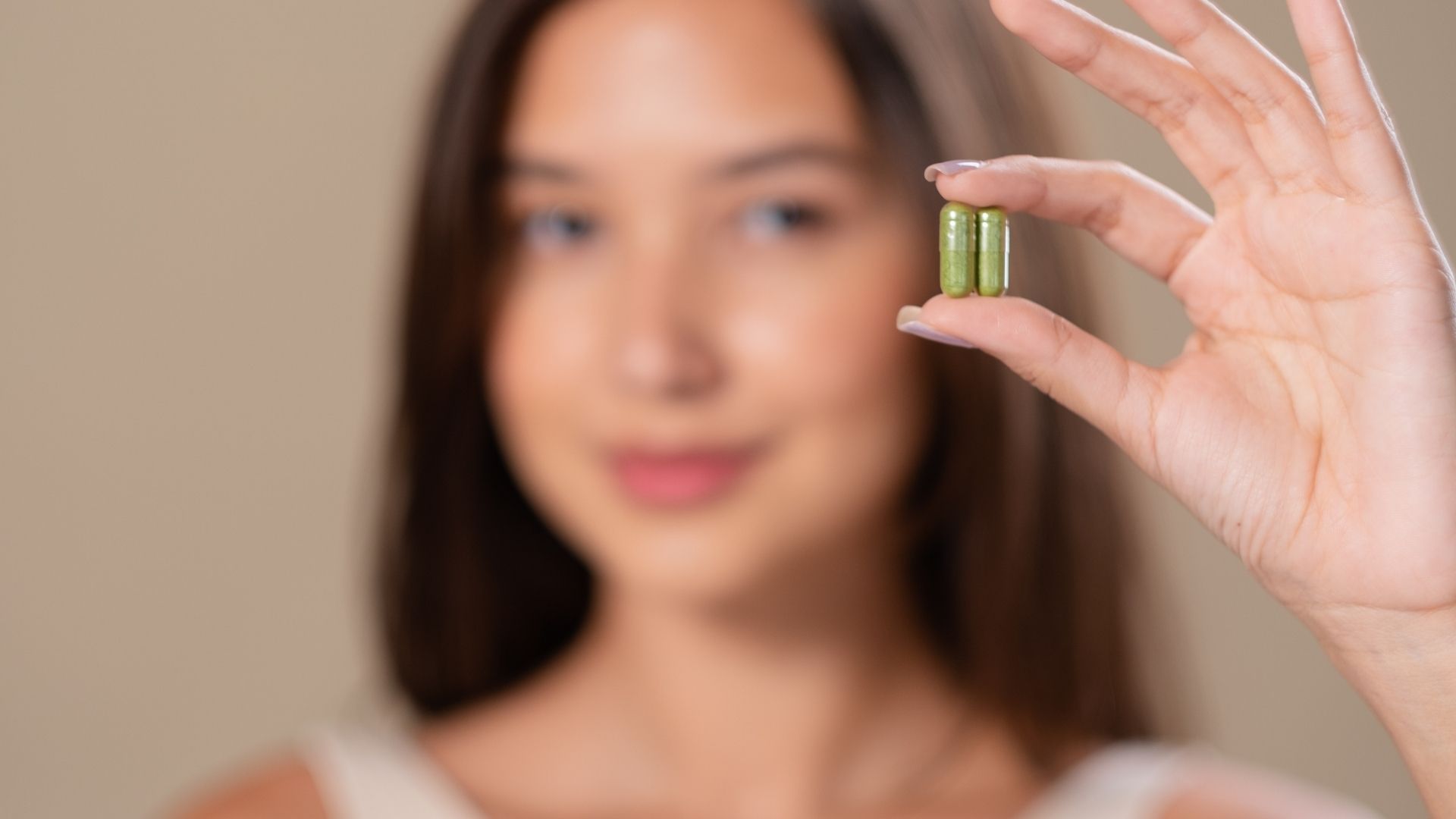 A person holds supplements in their hand