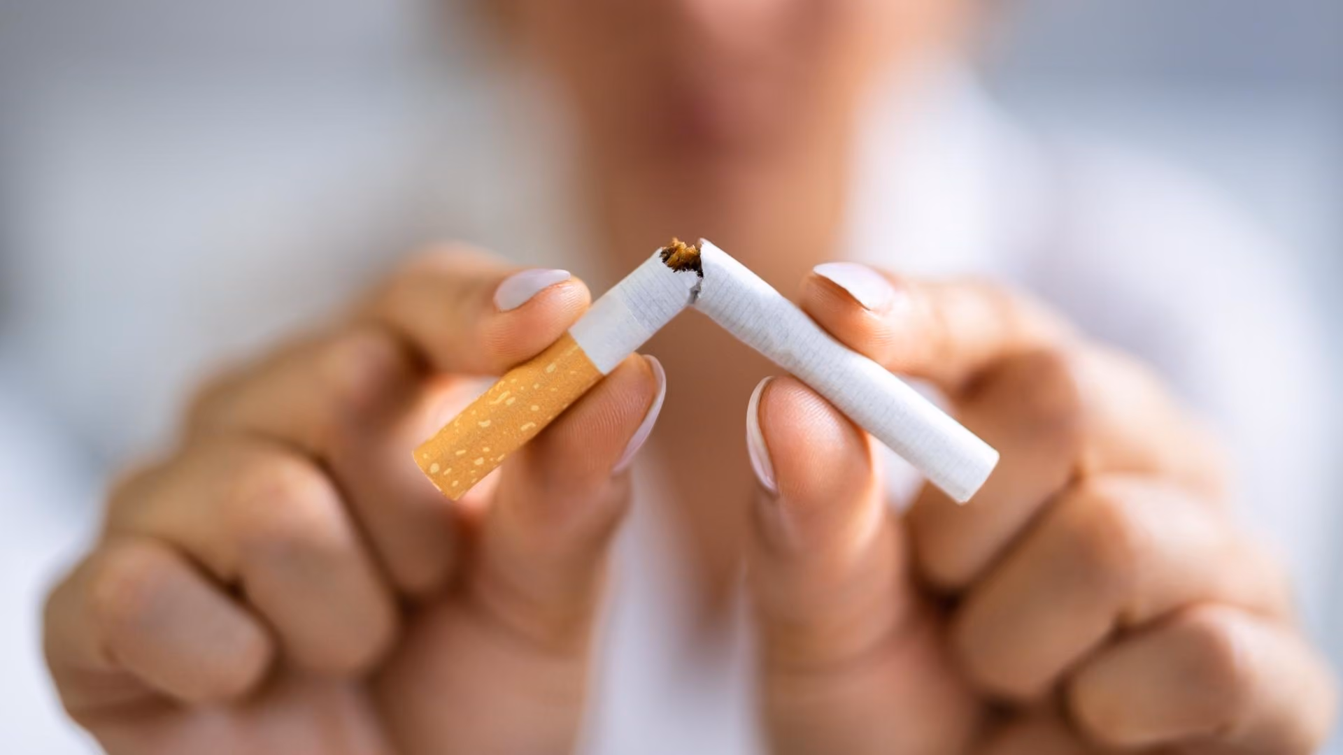 A person breaks a cigarette
