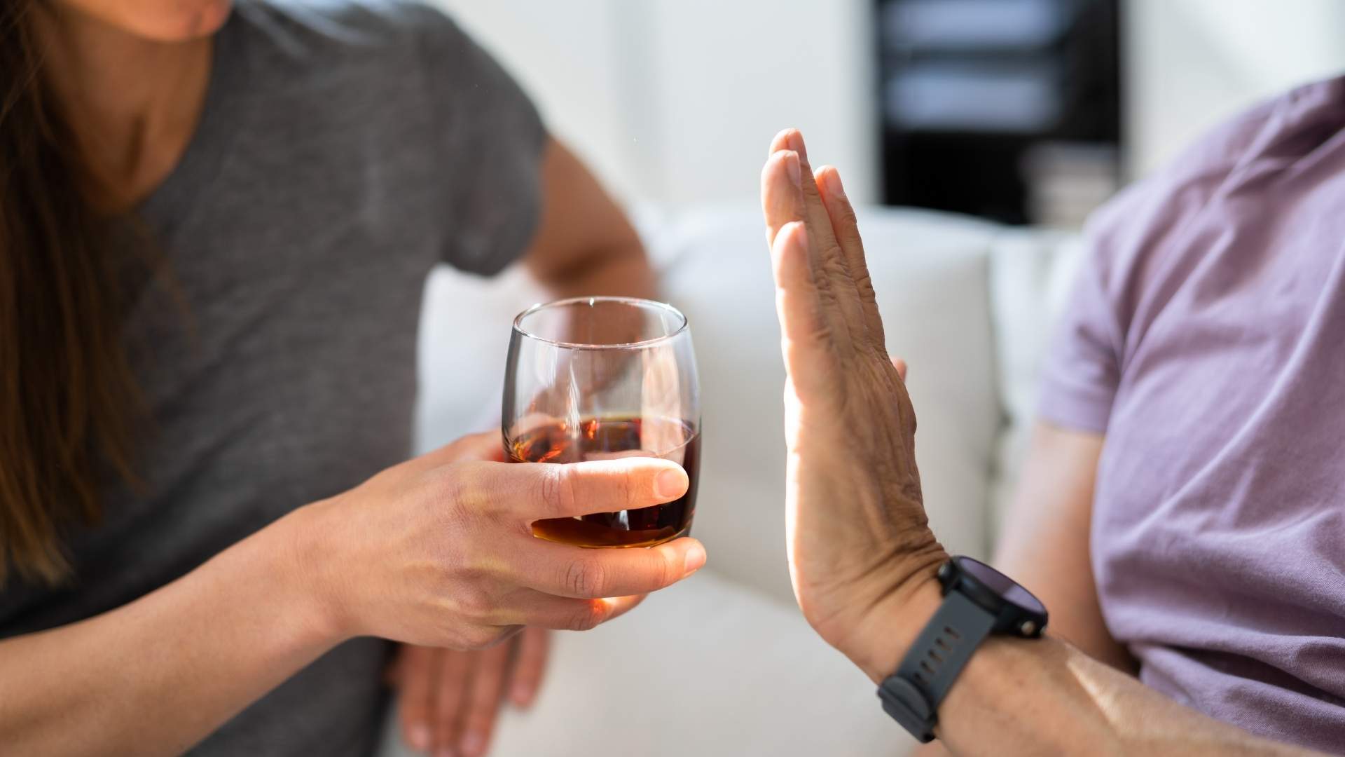A person refuses a glass of wine
